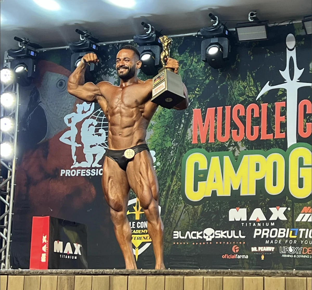 Matheus Henrique, personal trainer em Campo Grande MS, no palco segurando seu troféu